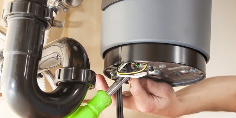 Monterey, California plumber servicing water heater pipe connection